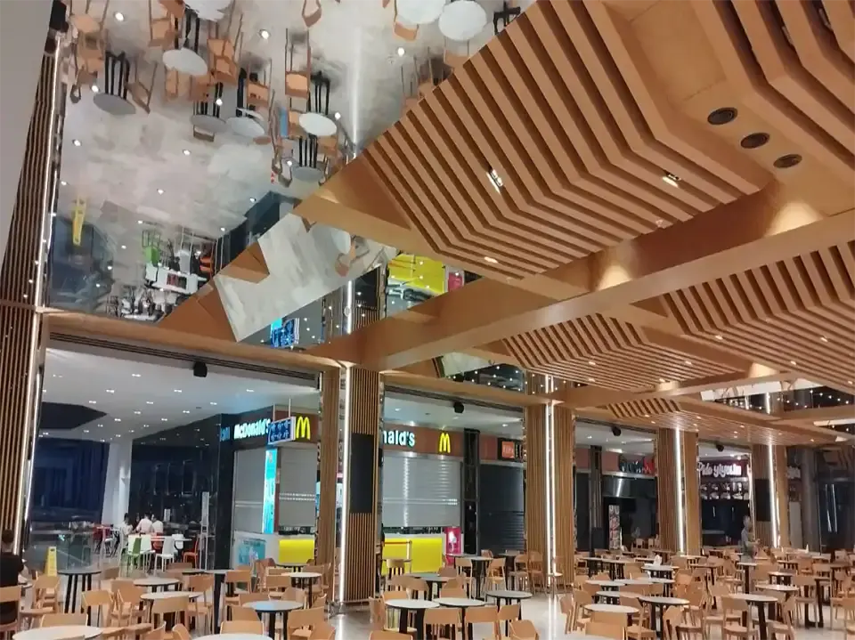 Yemek alanı dekorasyonunda kademeli ahşap çıtalı tavan, aynalı tavan paneli ve masa sandalye grupları