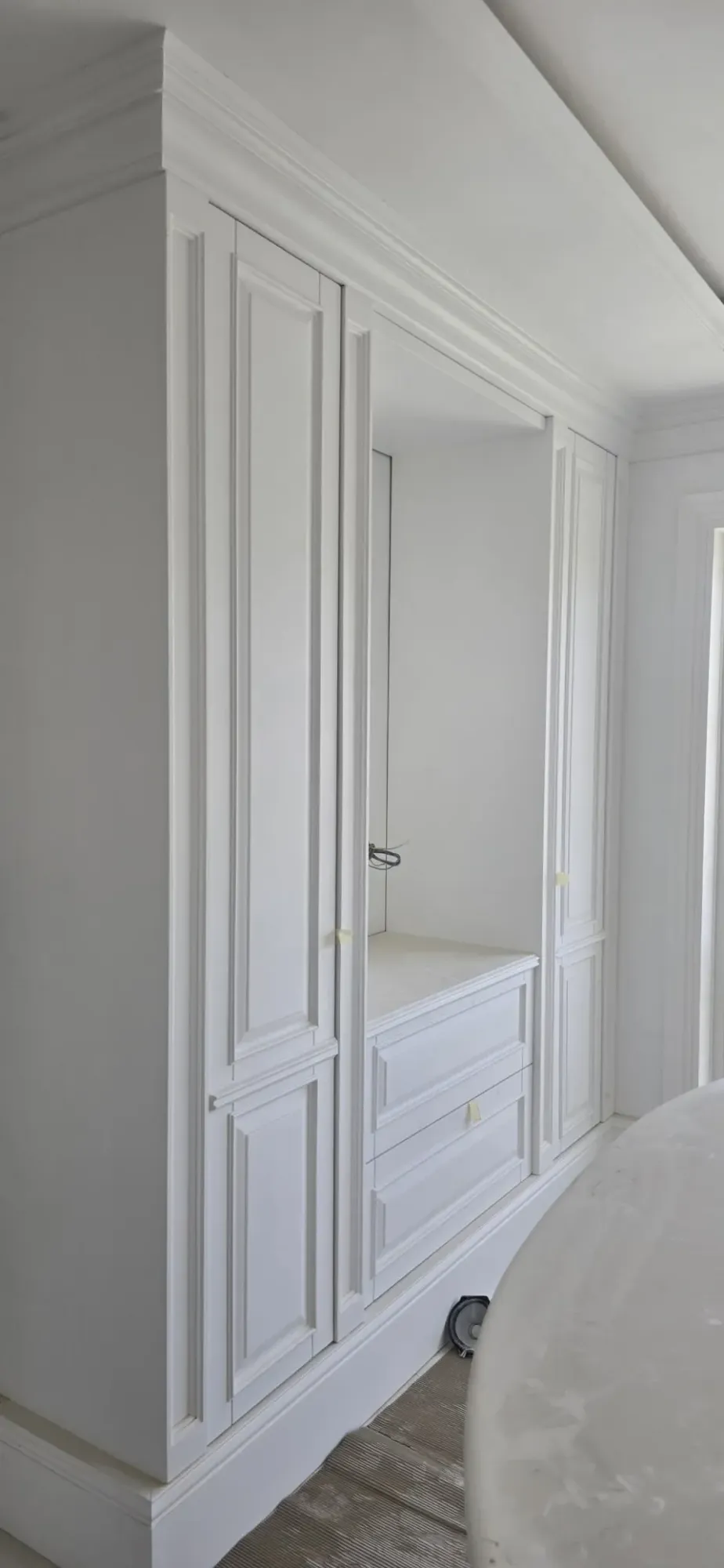 Askılık boşluklu ve iki çekmeceli beyaz lake gardırop, villa yatak odasında
